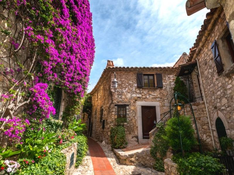 Alley and houses covered with flowering vines in Eze Village